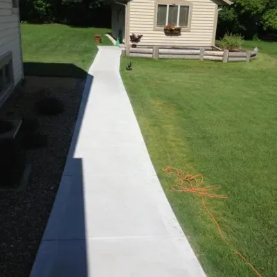 Custom concrete walkway design enhances outdoor access and aesthetic appeal in residential backyard