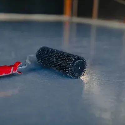 Custom epoxy surface application process in West Allis WI featuring a roller tool for finishing touches