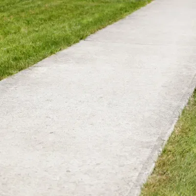 Driveway pathway leading through green grass in Brookfield, Wisconsin on a clear day