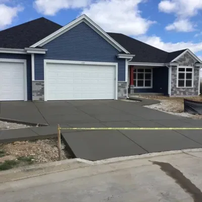 Concrete driveway pouring process in Waukesha, showcasing a new residential construction site