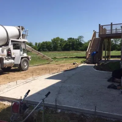 Concrete demolition and pouring process in Waukesha under clear blue sky with construction team at work