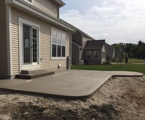 Concrete outdoor flooring project in Wauwatosa showcasing modern home patio design and landscaping details