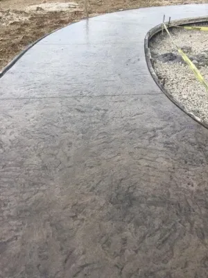 Stamped concrete patio construction underway in Pewaukee, Wisconsin, featuring a sleek design and curvature