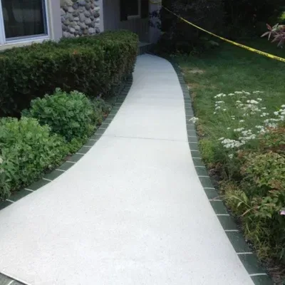Concrete walkway installation process in residential landscaping at sunset