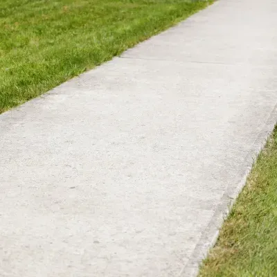 Driveway pathway leading through green grass in Brookfield, Wisconsin on a clear day