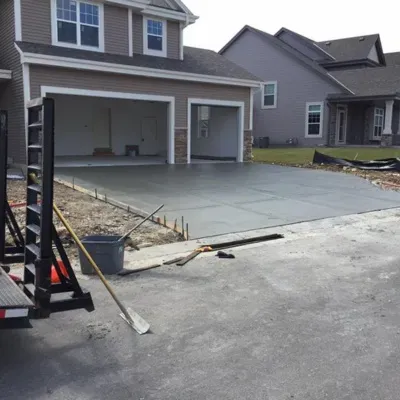 Driveway demolition and concrete pouring in Waukesha residential area during early spring