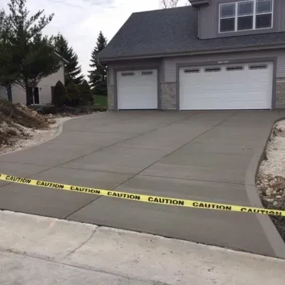 New poured concrete foundation and driveway installation in New Berlin, WI with caution tape for safety