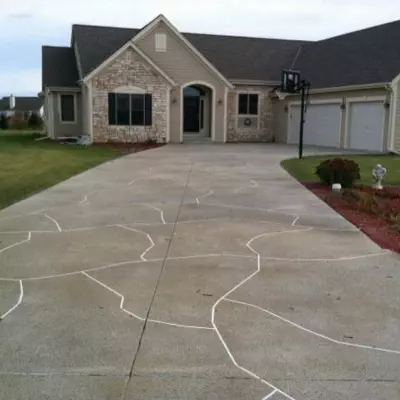 Colored concrete driveway enhances curb appeal of a residential house in Waukesha during a cloudy day