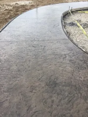 Stamped concrete patio construction underway in Pewaukee, Wisconsin, featuring a sleek design and curvature